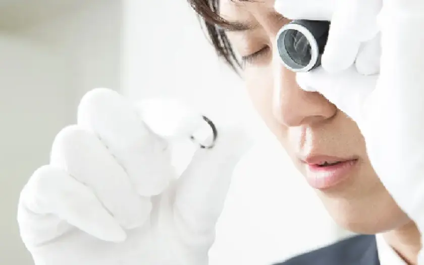 ブランドバッグを丁寧に査定する様子